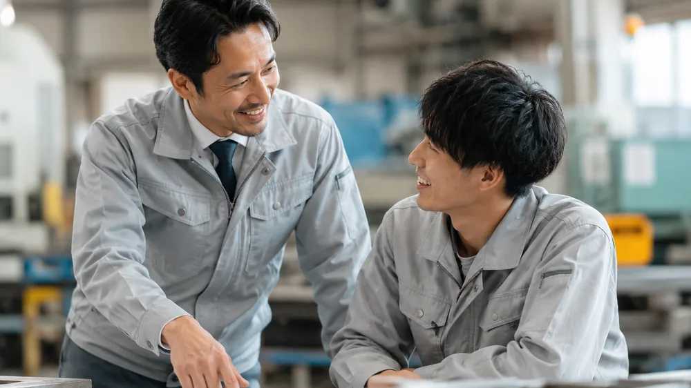 打ち合わせをする電気工事会社の社長と若手